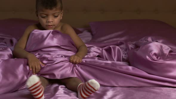 Boy Moving Feet on Bed.