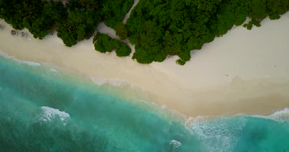 Beautiful above abstract shot of a sandy white paradise beach and aqua blue ocean background in vibr