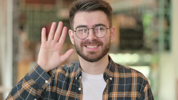 Portrait of Cheerful Young Man Waving, Hello 