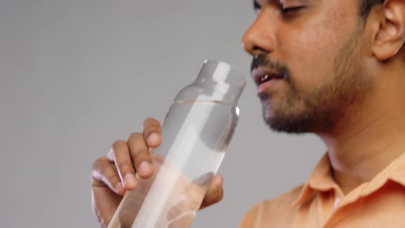 Happy Indian Man Drinking Water From Glass Bottle