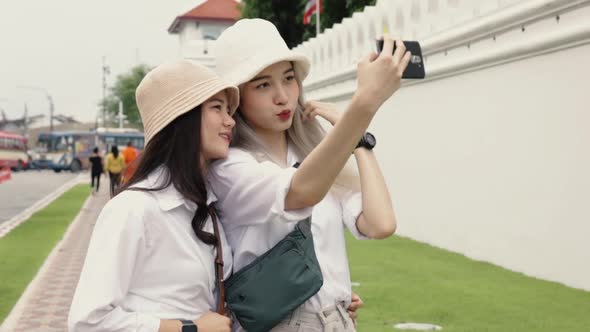 Happy Asian lesbian couples selfie video chat with friends enjoying traveling in Thailand.