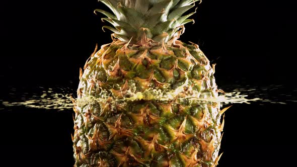 Half Pineapple Falling and Splashing on Black Background