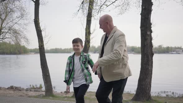 Portrait Adorable Grandfather and Cute Little Grandson Walking in the Park Together