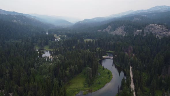 Reveal drone shot of kayakers on the winding Payette River in the Idaho forest. This cinematic 4K wi