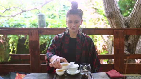 Young Woman Demonstrates a Bowl of Tea to the Camera