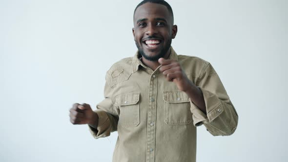 Portrait of Carefree African American Man Dancing Enjoying Music on White Background