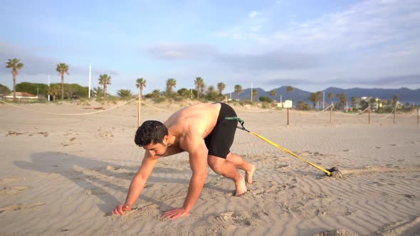 shirtless athlete preparing to perform resistance exercise with weight