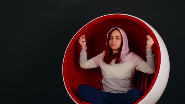 Young Woman Meditating in Ball Chair