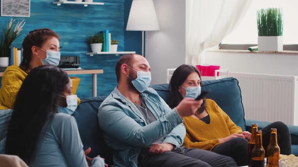 Mixed Races of Friends Looking at Tv Man Holding Remote Control