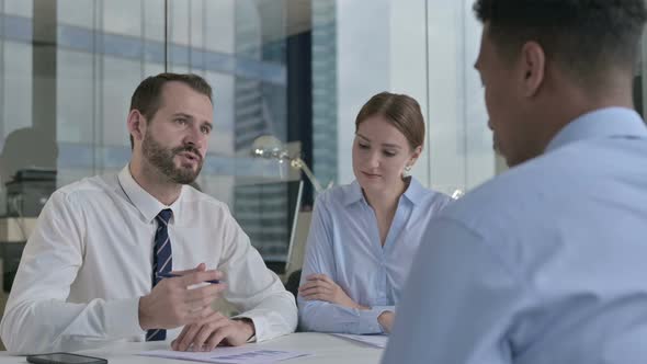 Rear Back View of Guy Talking To Business People in Office 