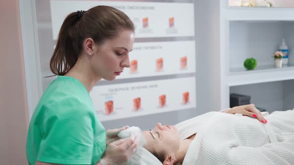 Female Beautician Makes Face Rejuvenation and Cleansing Procedure for Girl