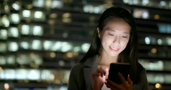 Business woman use of cellphone city city at night