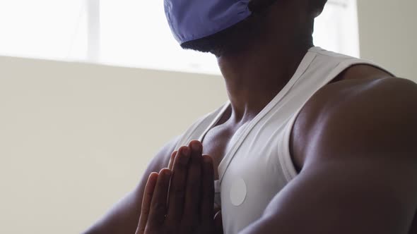 Fit african american man wearing face mask practicing yoga in yoga studio