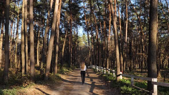 The girl is walking in the woods