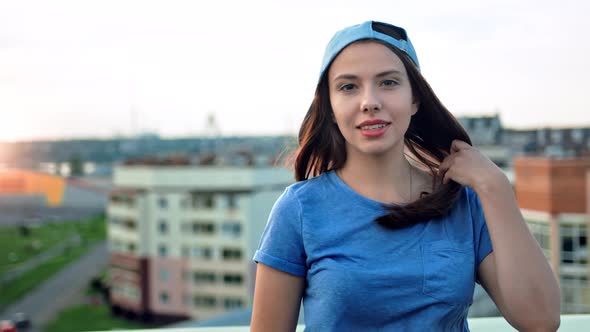 Portrait of Attractive Smiling Young Teenager Woman in Cap Touching Her Hair Outdoor