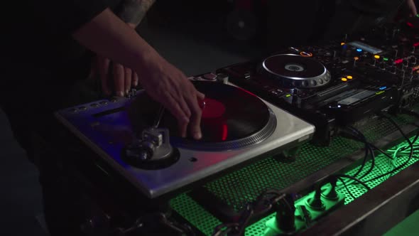 Professional African American Dj Mixing Track Using Vintage Vinyl Record Turntable in Nightclub