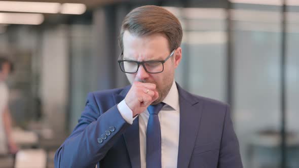 Portrait of Sick Businessman Coughing at Work