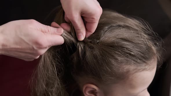 Mother Braids Daughter Pigtails on Hair Head