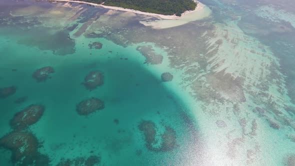 View of blue lagoon and green island in maldivian archipelago with turquoise water