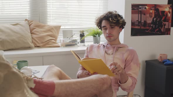 Guy Reading Book at Desk