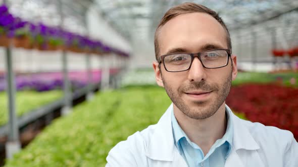 Medium Closeup Portrait Smiling Male Scientist Agriculture Worker Wearing Glasses Looking at Camera