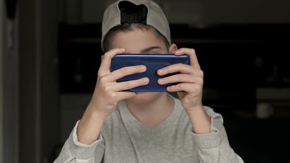 Boy Gamer Enthusiastically Playing a Game on a Mobile Phone