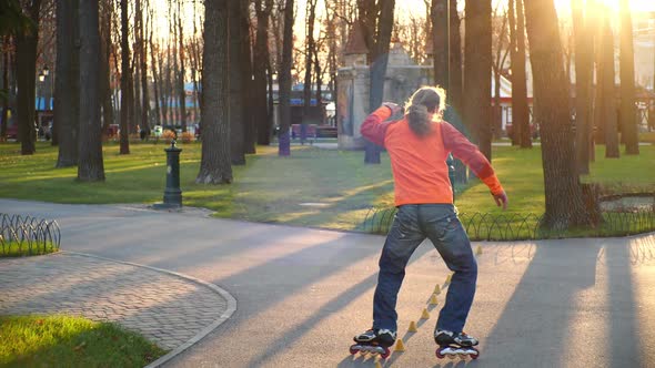 A Professional Roller Rides Great Backwards on Rollerblades Between Training Cones, Crossing Legs