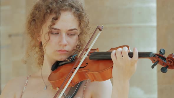 young curly blond woman the violinist: Musician playing violin