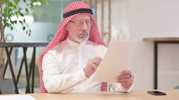 Senior Old Arab Businessman Writing on Paper