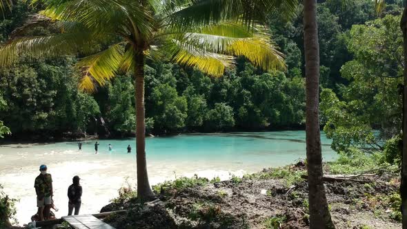 Aerial view in low altitude of a beautiful beach lagoon in an island with clear blue turquoise water