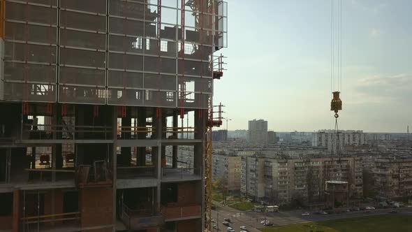 Raising a Cistern with Concrete on the Roof of a Highrise Building Under Construction with Workers