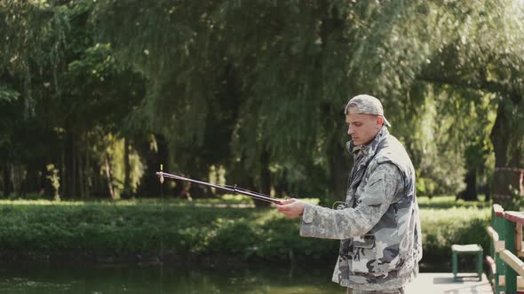 Confident Fisherman Preparing a Rod for Fishing at the Pond