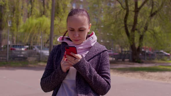 Close Up of Young Woman with Mobile Phone on Street in Sunny Weather