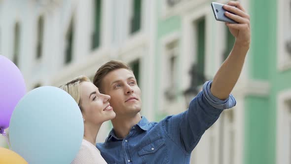 Beautiful Couple Taking Selfie and Kissing Before Camera, Romantic Date, Love