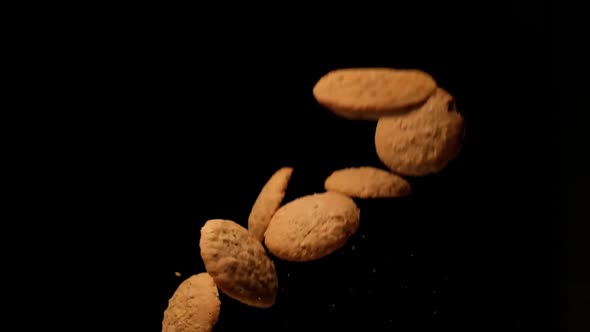 Slow motion cookies flying on black background.