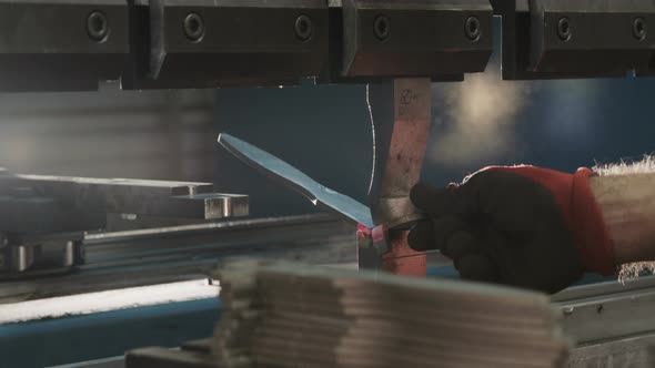 Close up of a Production line worker bending metal parts with a machine