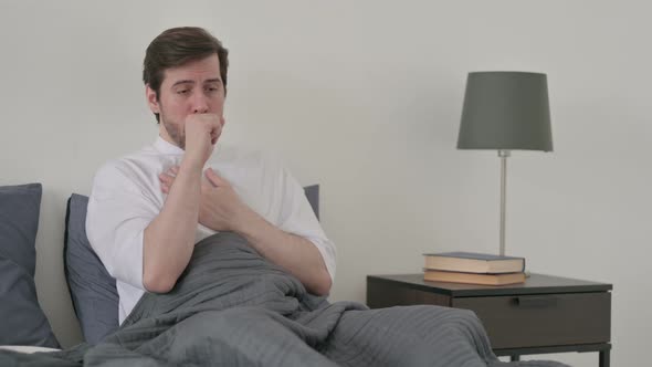 Young Man Coughing While Sleeping in Bed