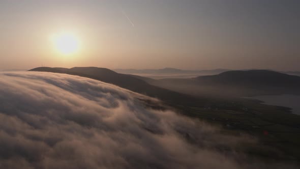 Early morning clouds drift over the mountains in Co Kerry Ireland as the sun shines during the summe