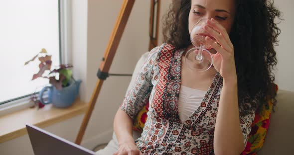 Woman drinking wine and working at home