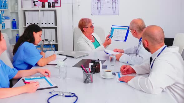 Medical Nurse Writing on Clipboard During Healthcare Seminar