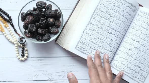 Holy Book Quran and Rosary on Table Close Up