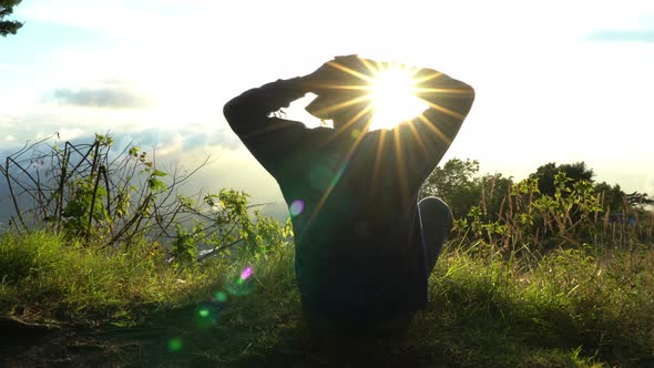 Man Hermit Meeting Up Sun Rise on the Edge of Mountains. Doing Meditation in Sun Light.