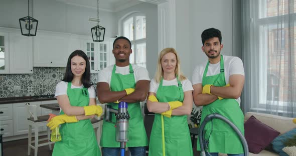 Cleaning Team in Uniform and Gloves Standing in front of Camera in Modern Room