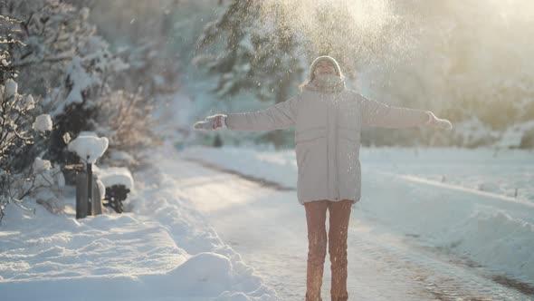 Slow Motion Young Woman Throwing Snow in Winter Park