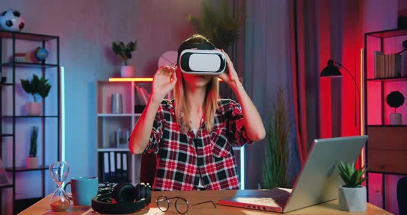 Blondie Sitting at Her Workplace in Home Office in the Evening and Working in Virtual Reality