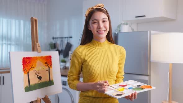 Portrait of Asian young artist girl drawing art picture, creating artwork with watercolor and brush