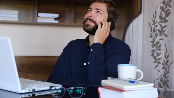 Smiling Young Man Recording Voice Recognition Message on Phone