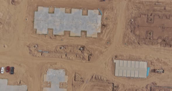 Construction of Aerial Top View on Pouring the Foundation for a New Building with Suburbs