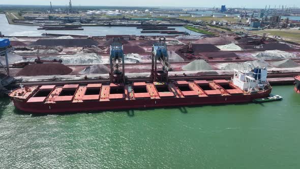 Cranes Unloading Commodities From a Bulk Carrier Ship at Port