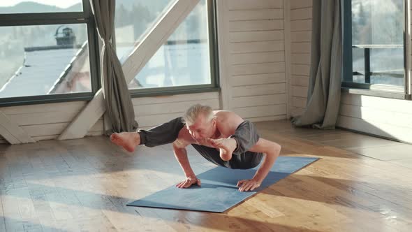 Mature Man Amongst Doing Power Yoga Exercises